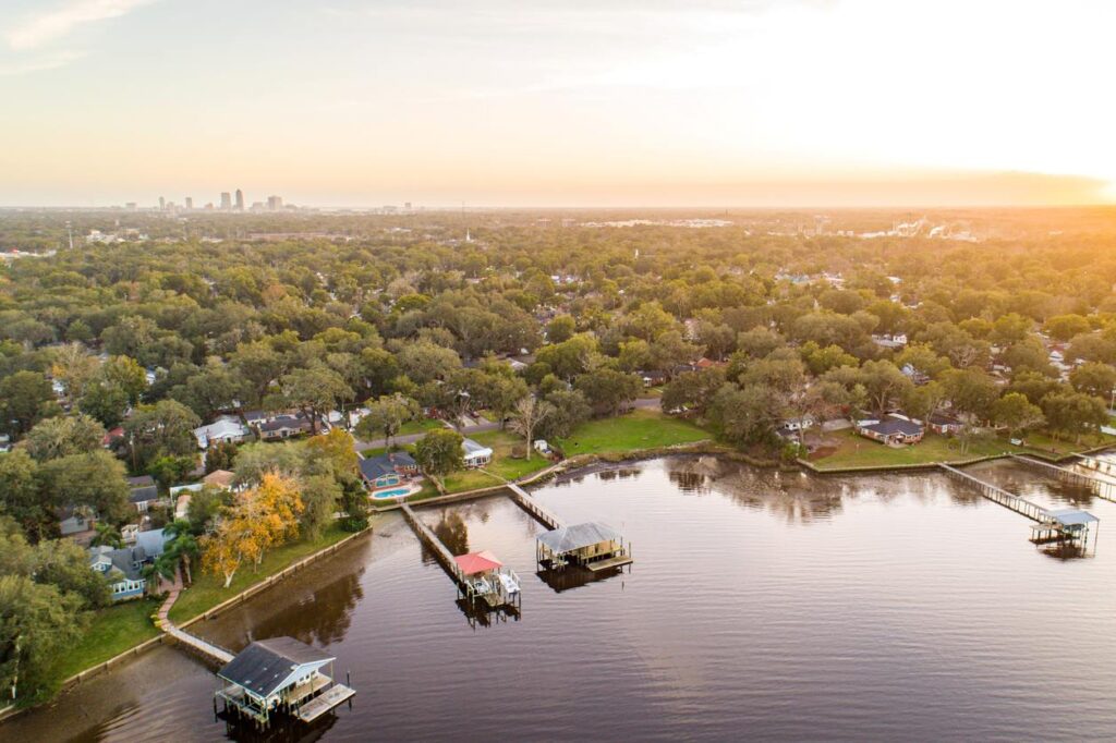 A riverside neighborhood in Jacksonville, FL, at sunset, with the downtown skyline in the distance.