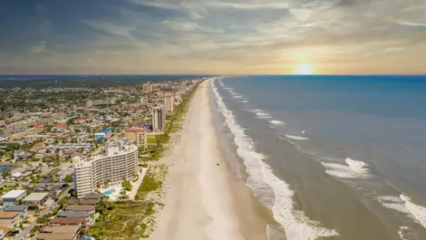 The Jacksonville Beach at sunset with hotels and homes on the left.