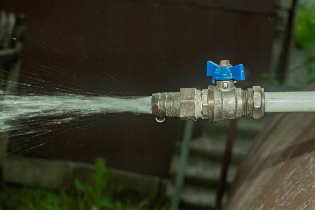 A pipe sprays water from its open tap.