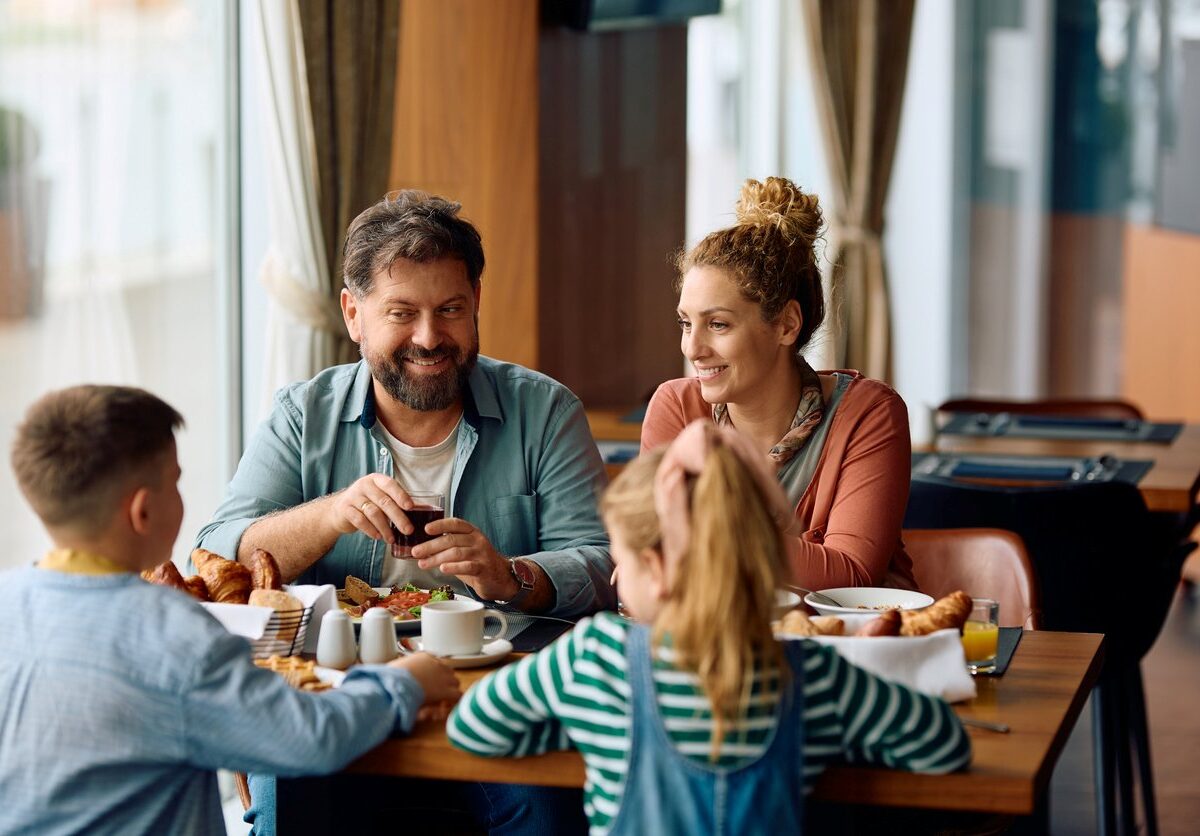 Happy parents enjoying in breakfast time with their kids.